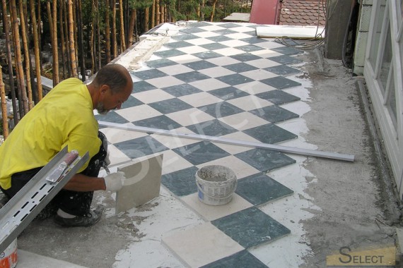 Laying the floor with marble street tiles in a checkerboard pattern