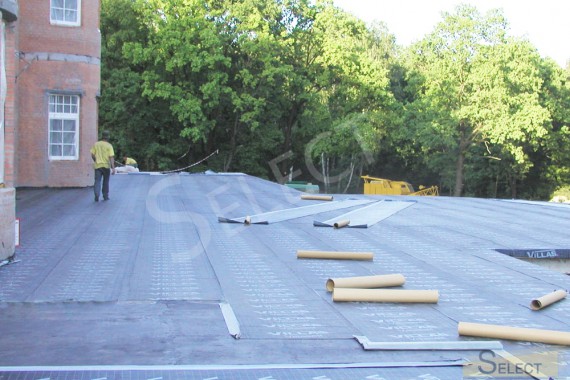Construction of the roof of the villa. Photo of work on laying rubberized canvas