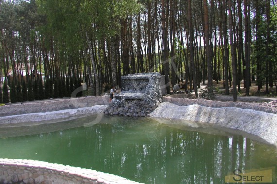 Artificial pond. Construction of an artificial waterfall on the other side of the pond