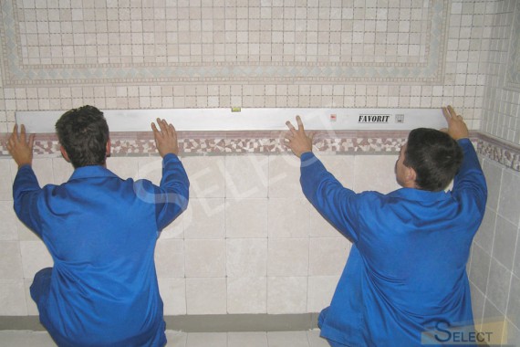 Photo Workers check the level of tile laying