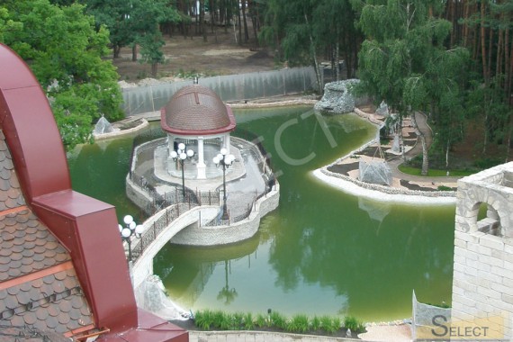 Final construction work of the artificial waterfall and pond with gazebo on the island